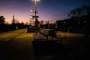 Photograph of people waiting for a train at twilight.