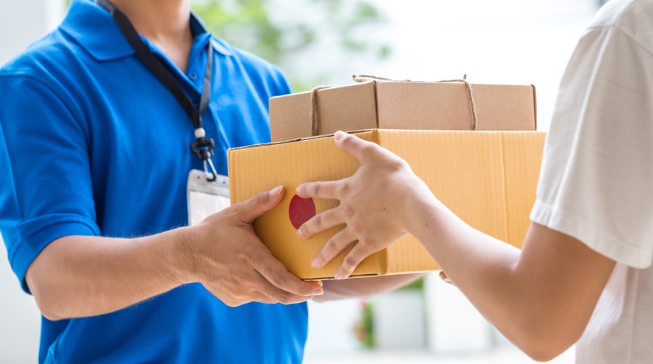 A courier handing two packages to a person.