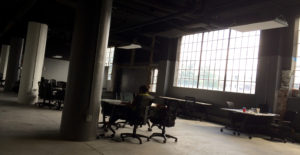 One woman working at a table in an office alone.